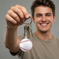 Man holding a keychain with a baseball design against a gray background
