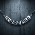 Silver Baseball Letter Necklace on blurry concrete background.