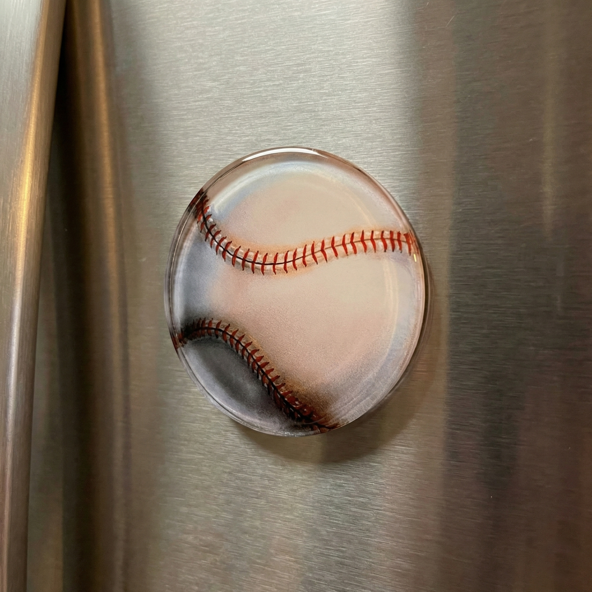 Baseball-shaped magnet on a metallic surface