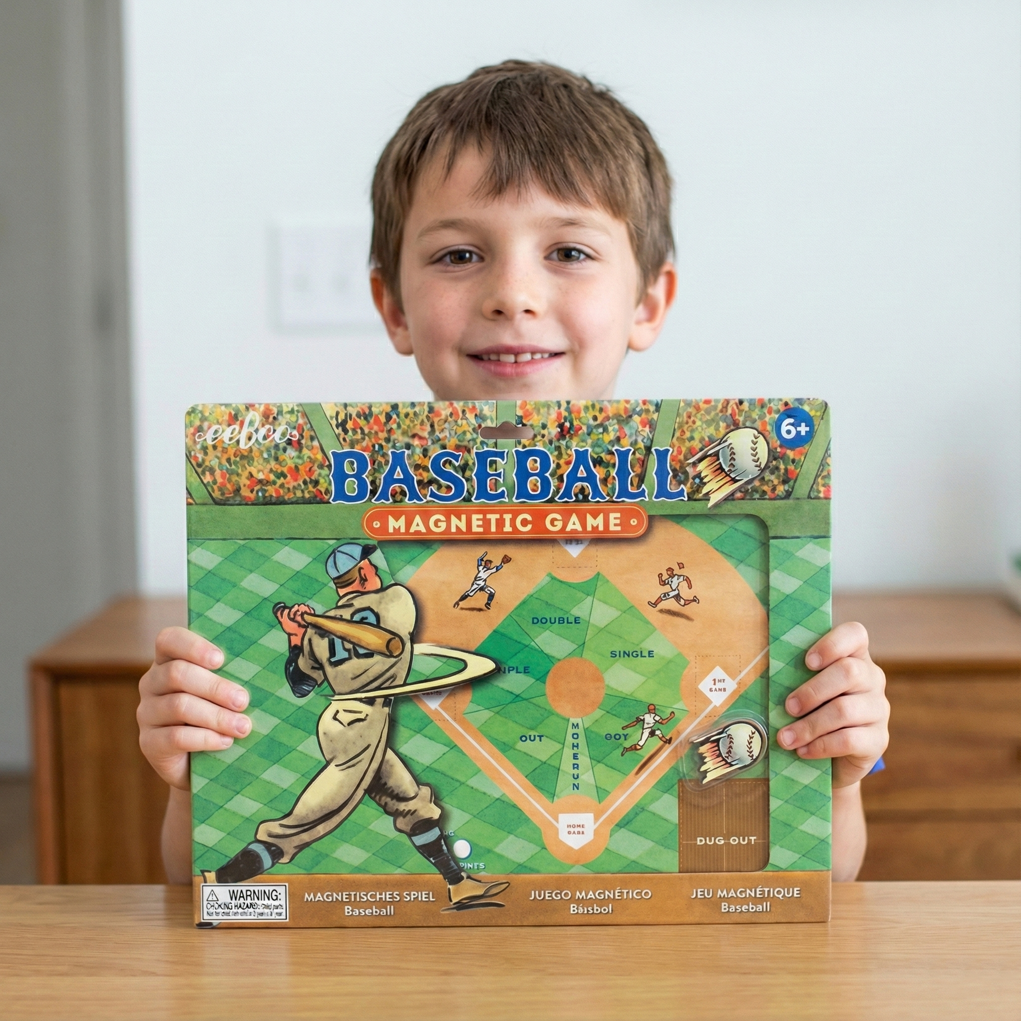 Child holding a baseball magnetic game box with a plain background