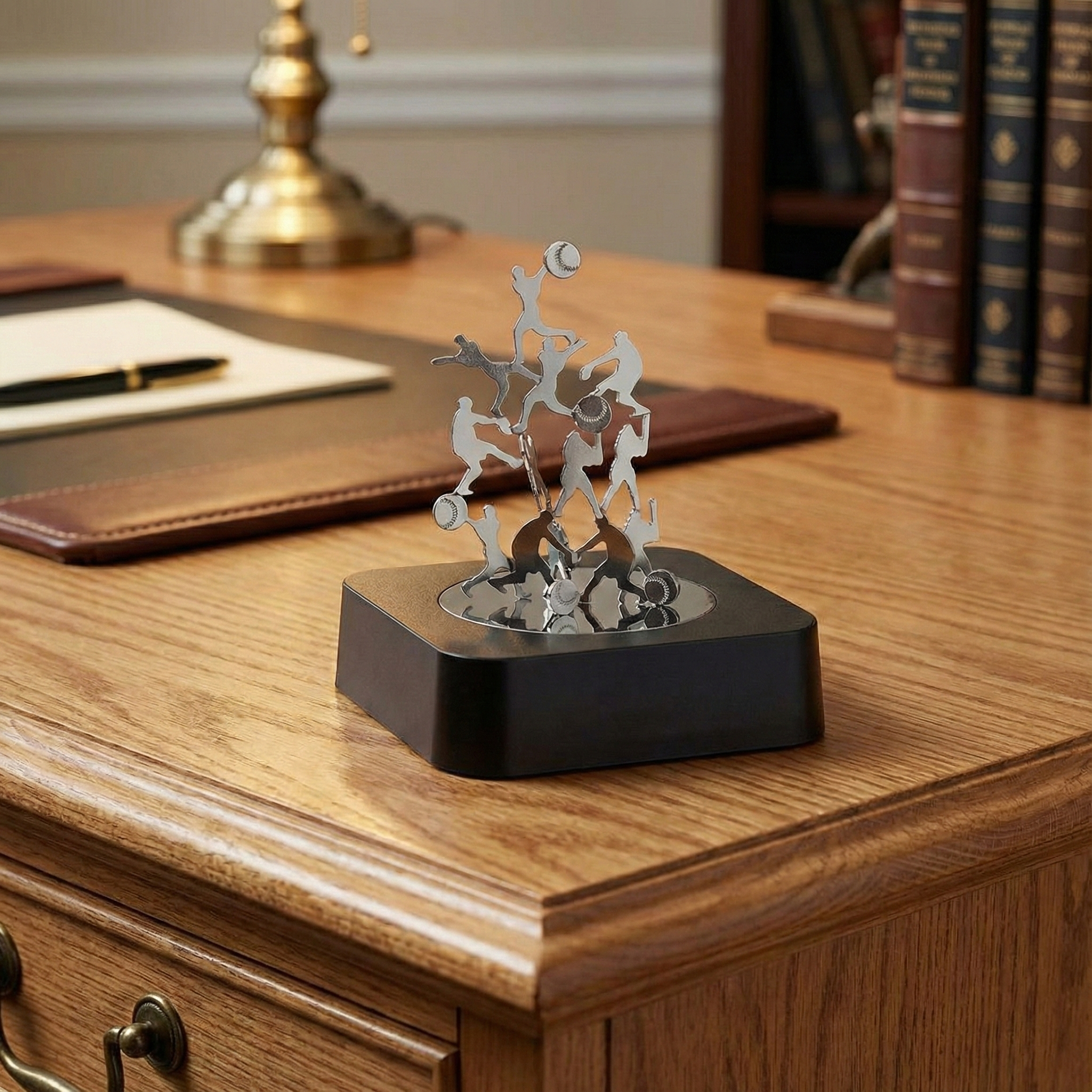 Baseball Magnetic Sculpture Block on a wooden desk with books and a lamp in the background