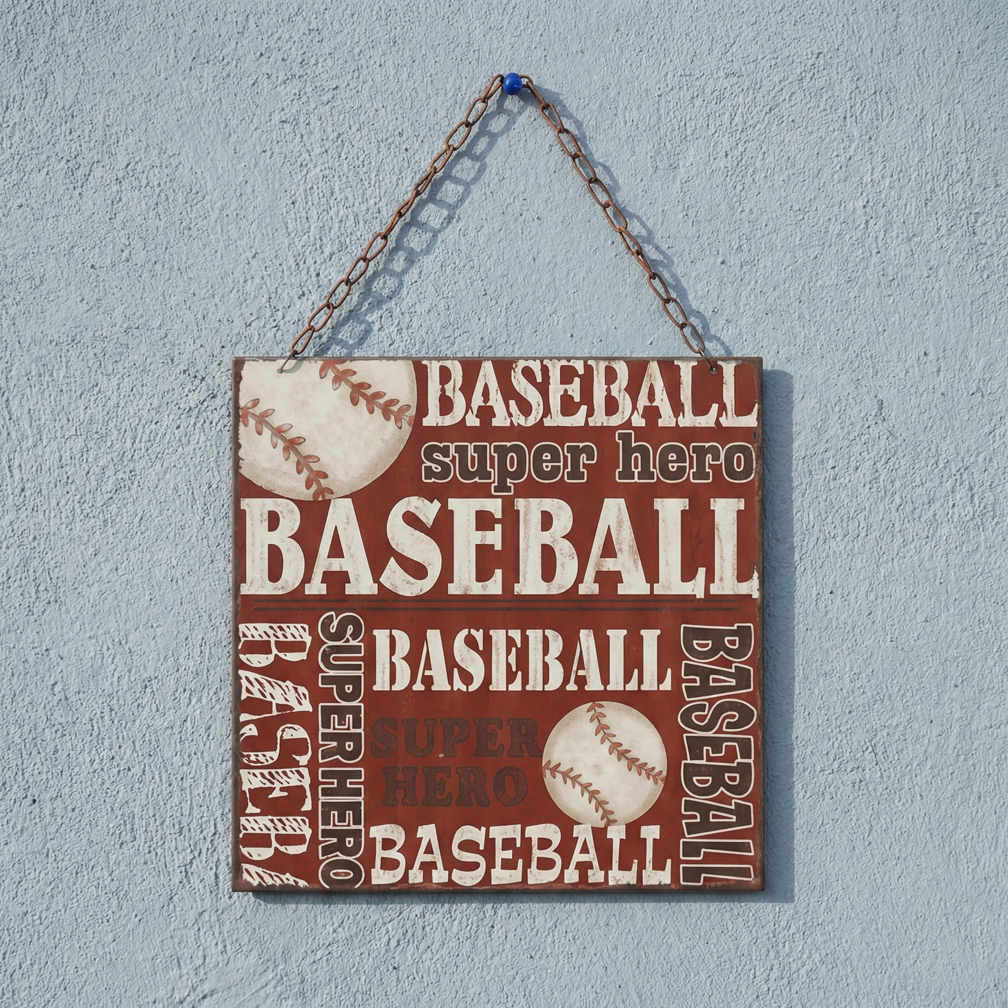 Decorative sign with 'BASEBALL super hero' text and baseball graphics on a light blue wall.