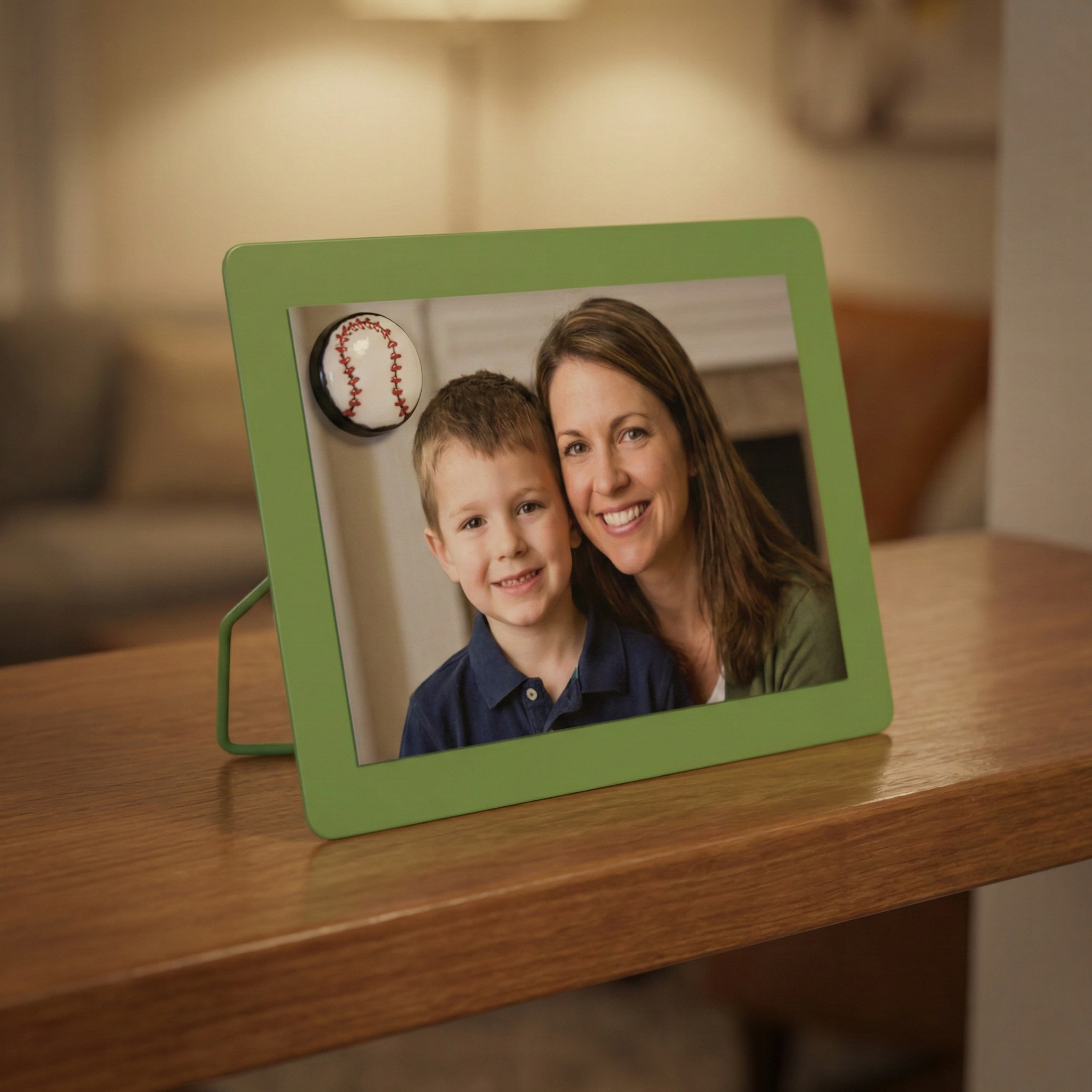 Green photo frame with a picture of a woman and a boy on a wooden surface.