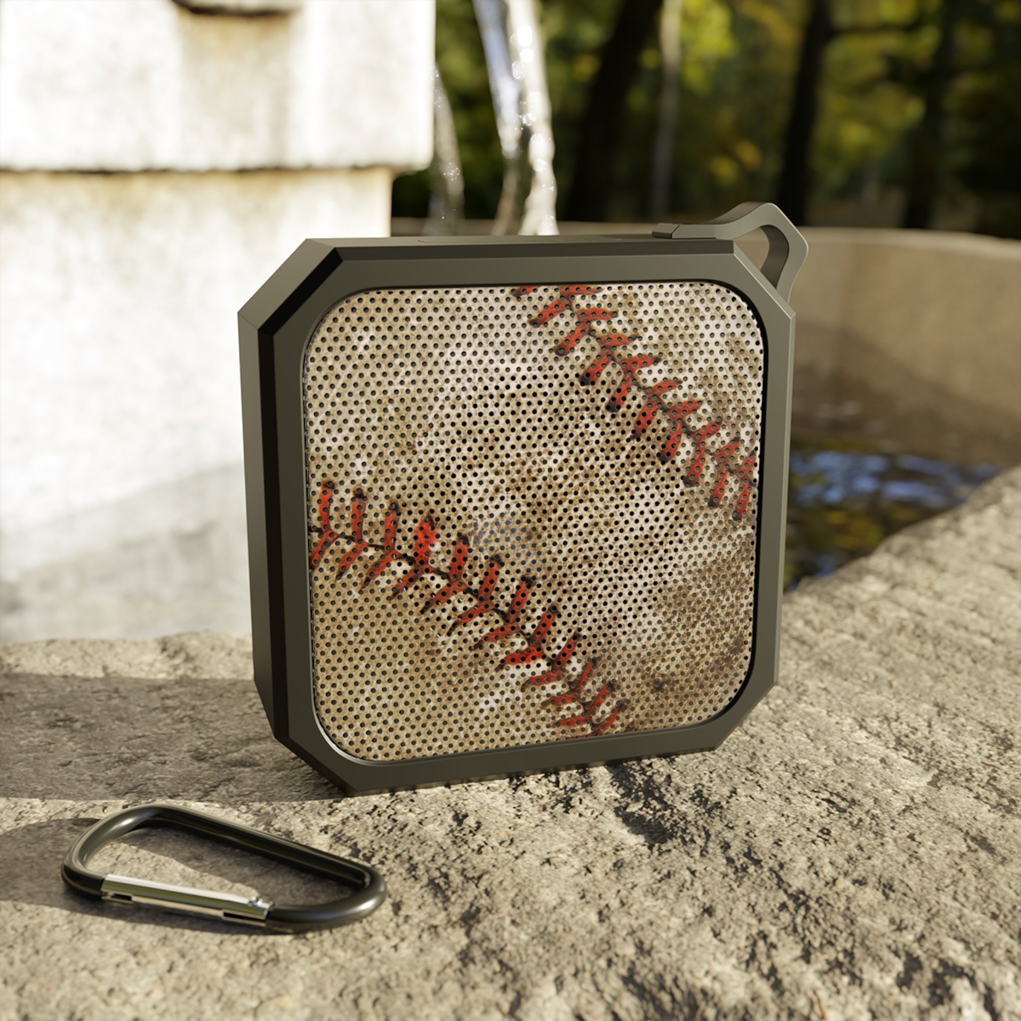 Portable speaker with baseball design on a stone surface