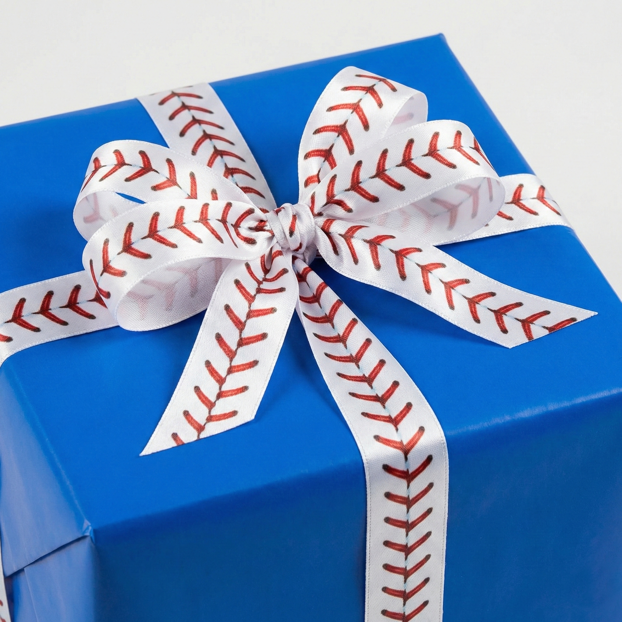 Blue gift box with a baseball-themed ribbon on a light gray background