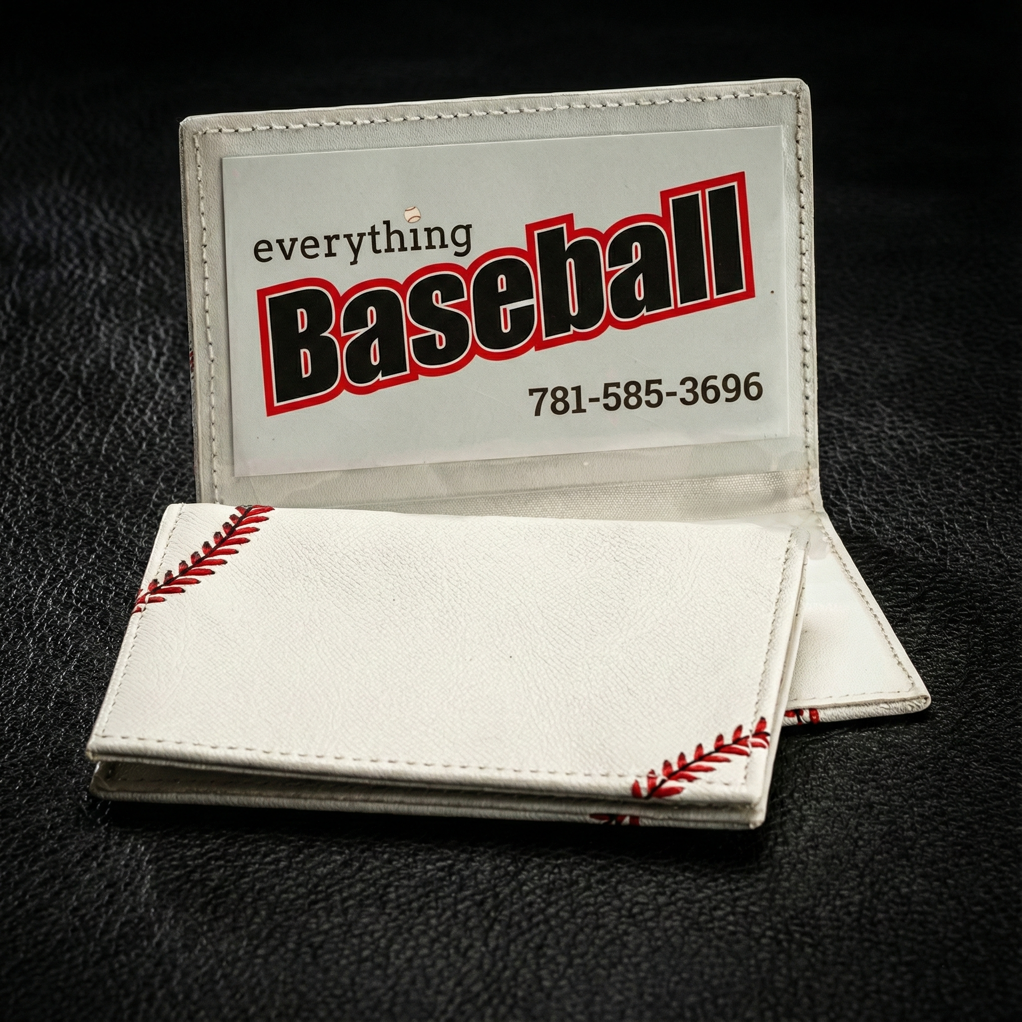 Baseball-themed business card holder with visible stitching on a black background