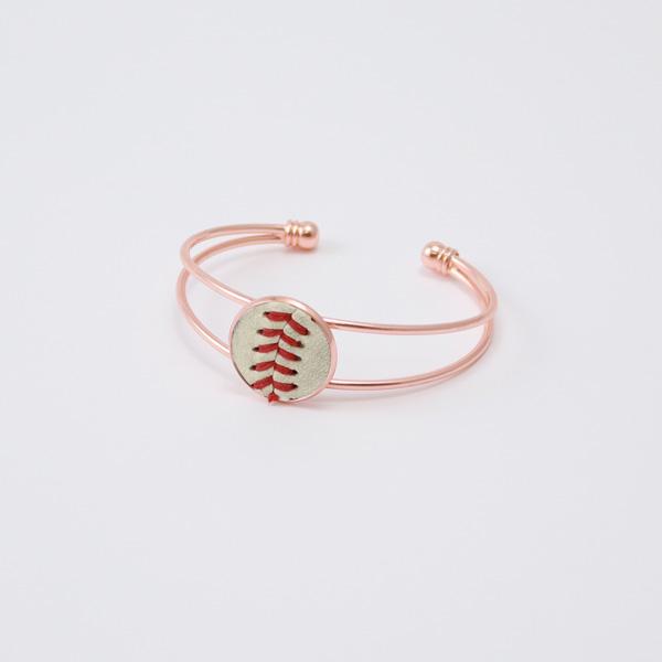 Rose gold bracelet with a baseball design on a light gray background