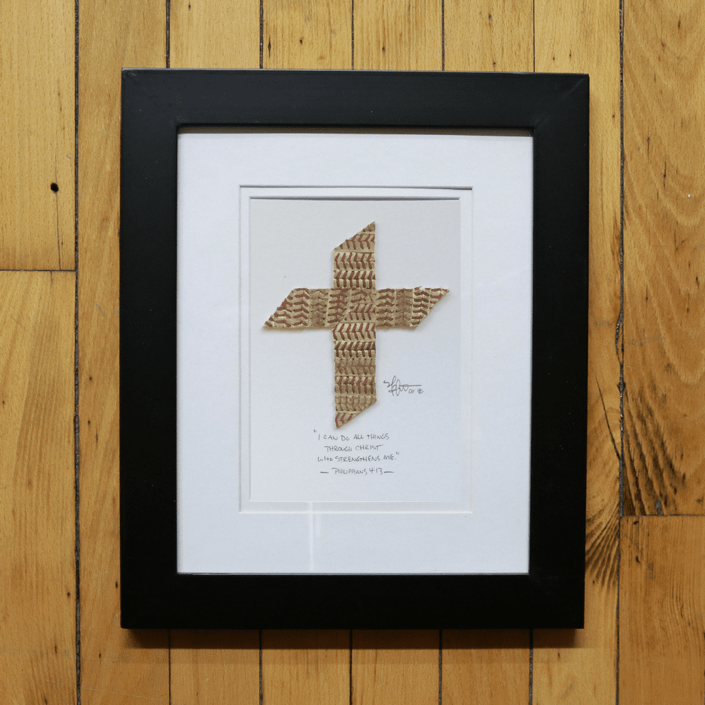 Framed baseball artwork with a geometric design on a wooden floor