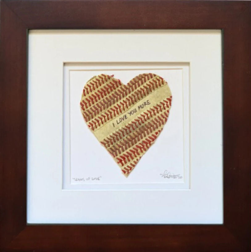 Heart-shaped framed baseball art with 'I Love You More' text in a wooden frame