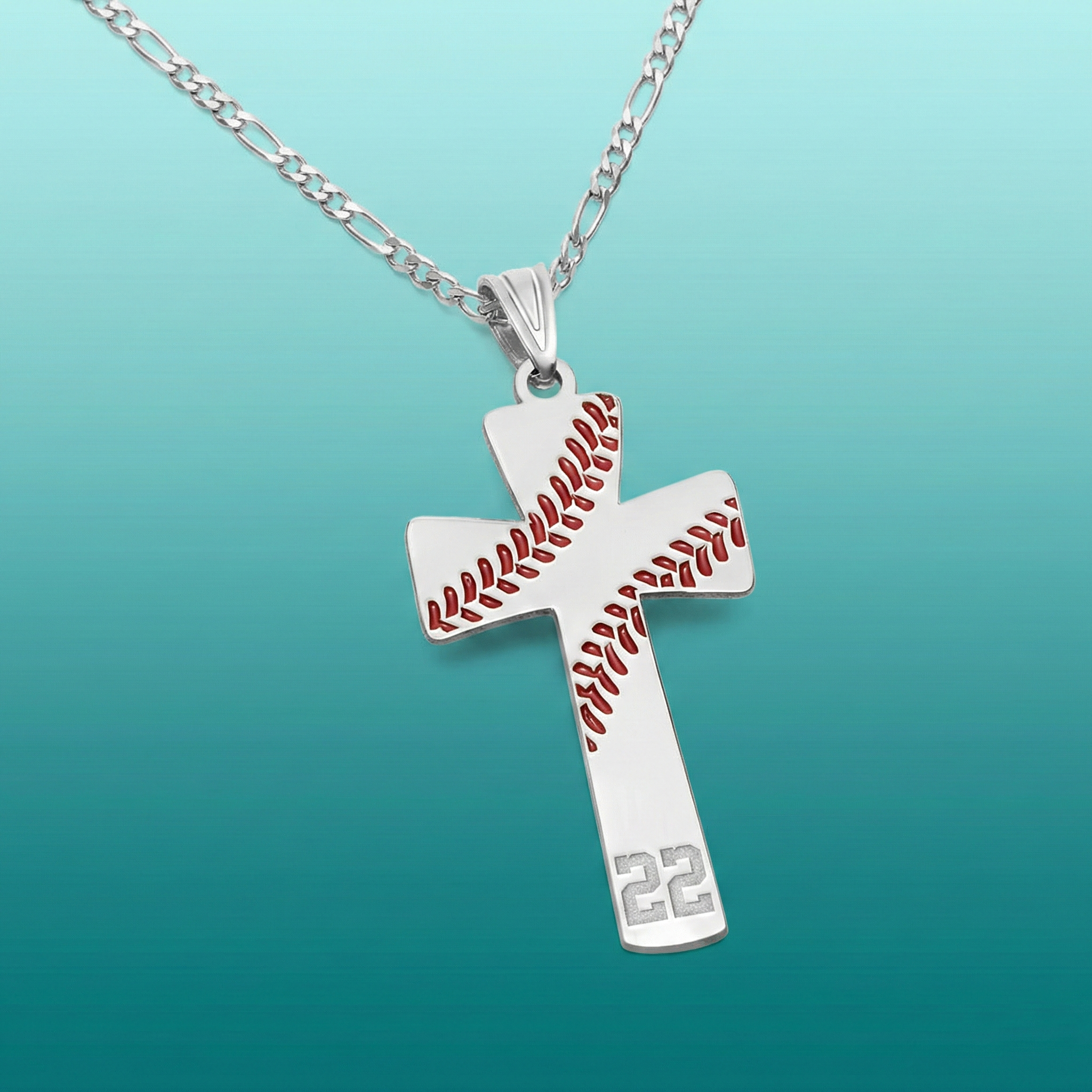 Cross-shaped pendant with baseball pattern and number 22 on a silver figaro chain against a teal background