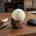 Baseball Stress Ball with Glove Stand on a wooden desk with a pen, notebook, and computer mouse.