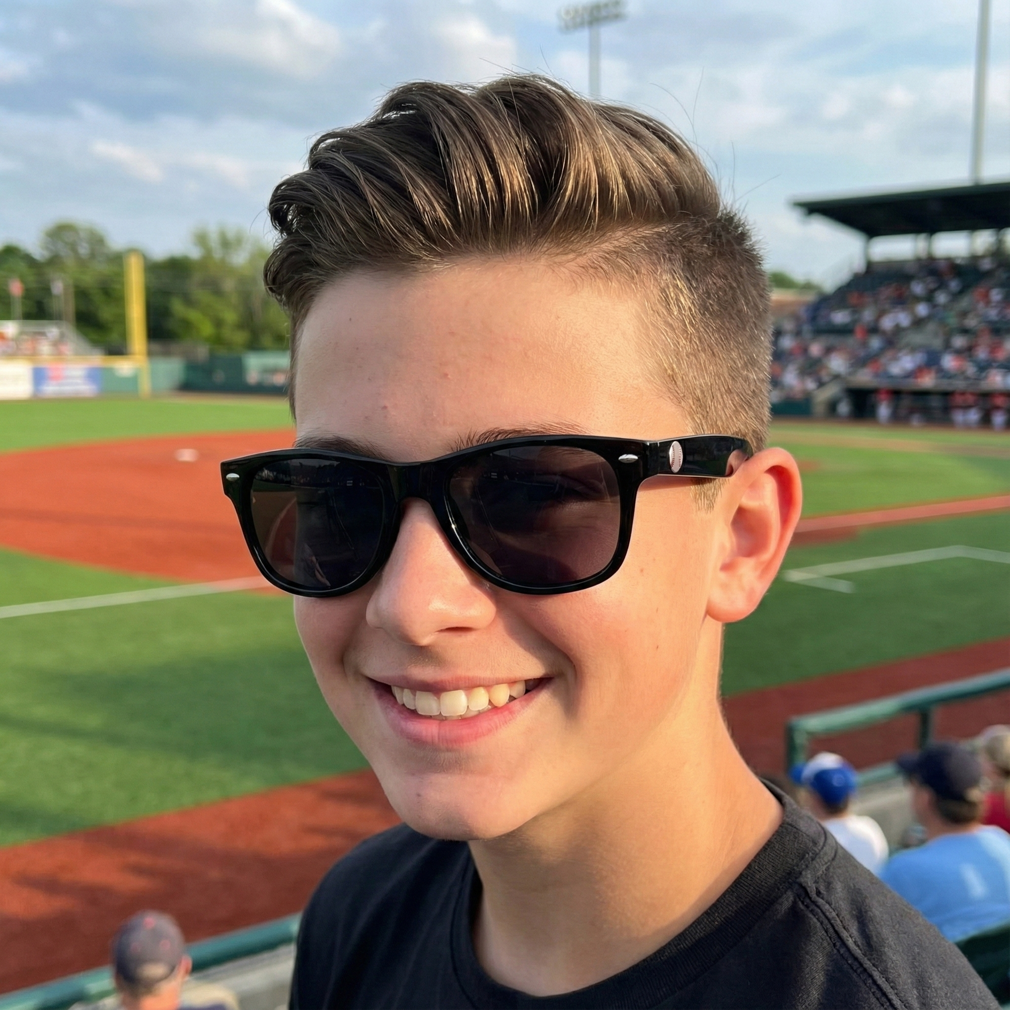 Young boy wearing sunglasses at a baseball game