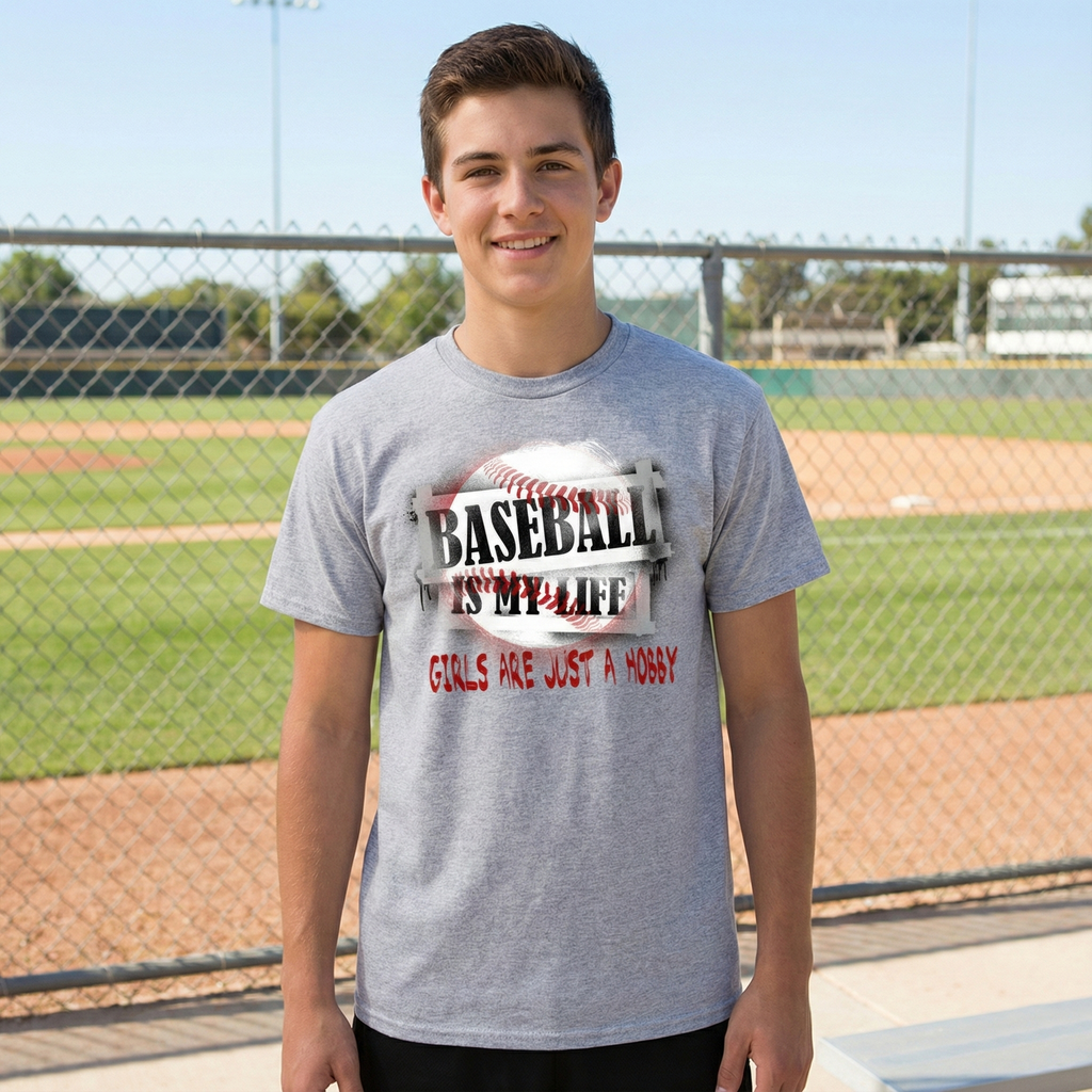 Person wearing a gray t-shirt with a baseball-themed design on a baseball field.