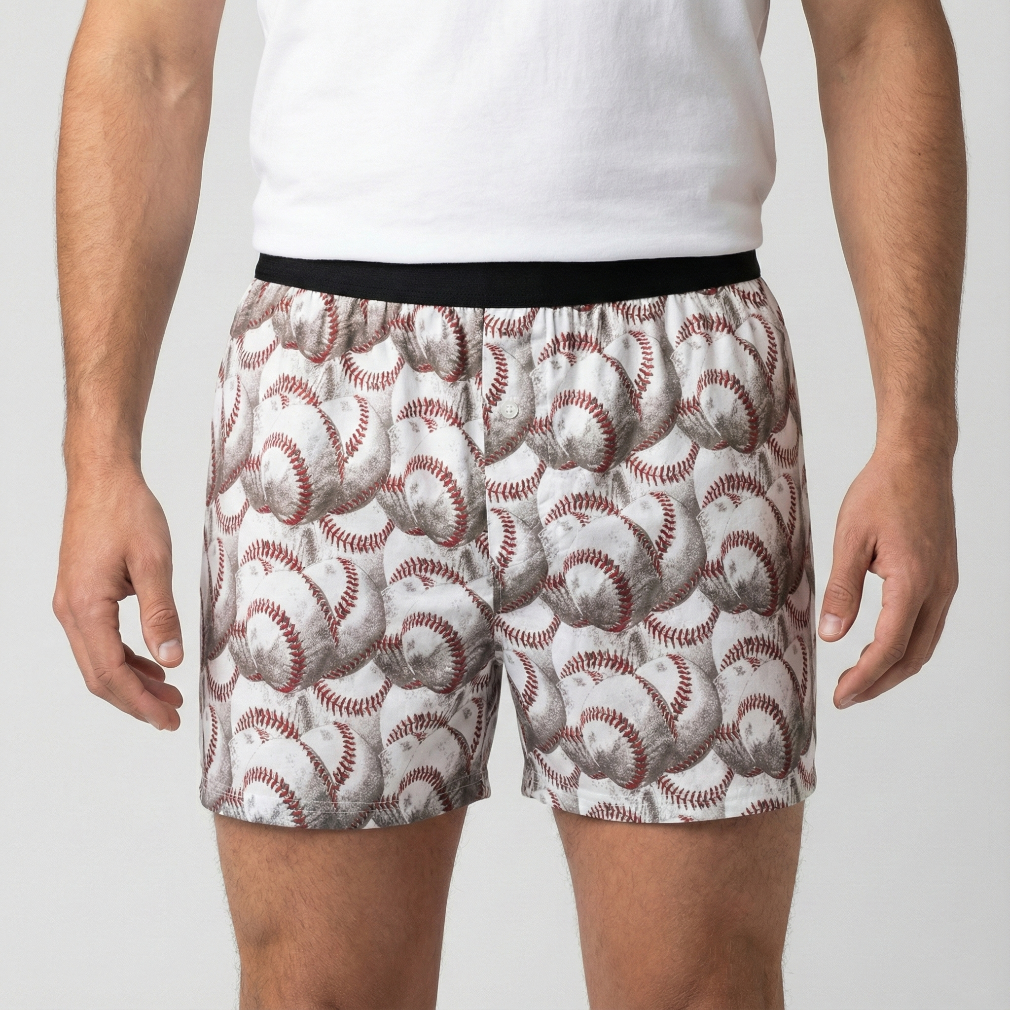 Person wearing boxer shorts with baseball pattern on a plain background