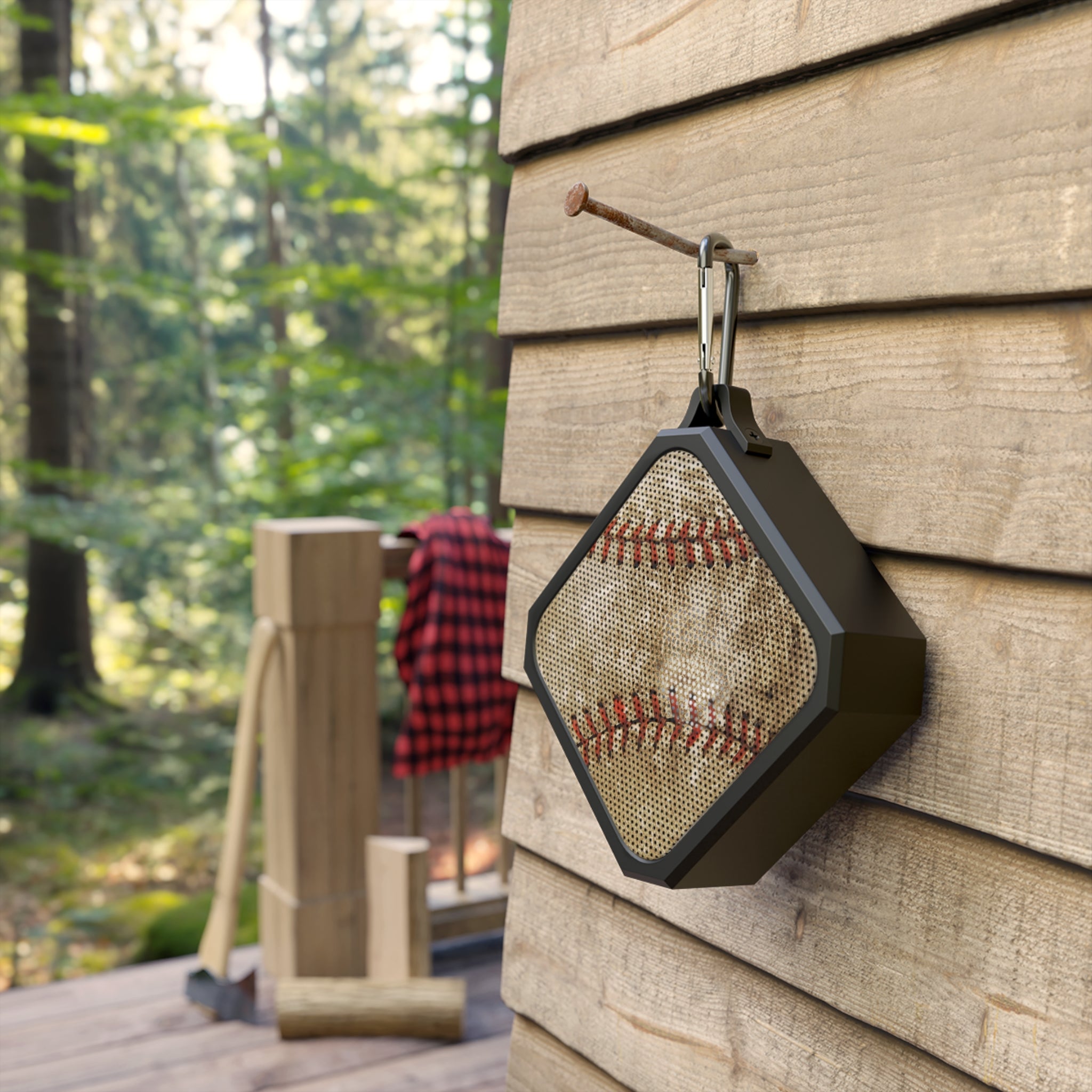 Baseball-themed speaker hanging on a wooden wall with a forest background