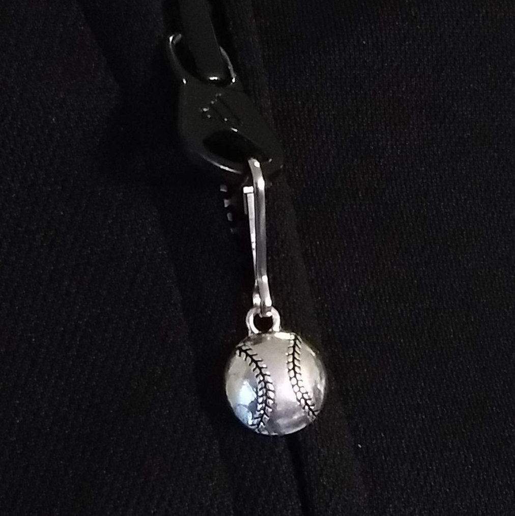 Silver baseball zipper pull on a black background
