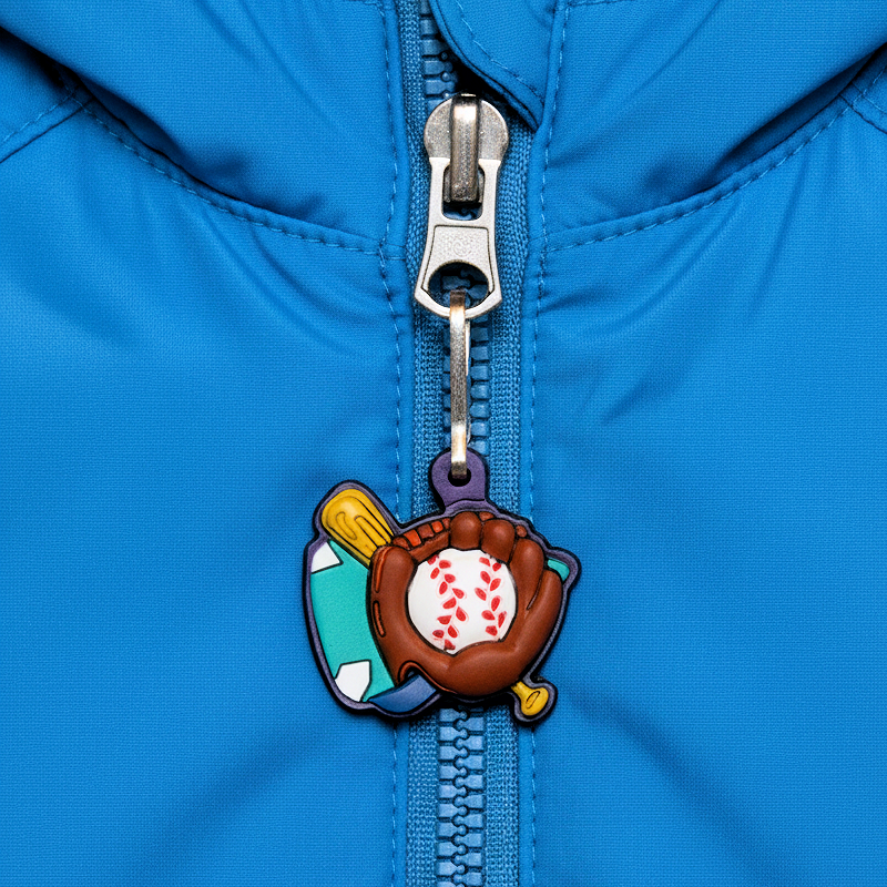 Zipper pull with baseball glove and ball rubber charm attached to a blue jacket zipper.