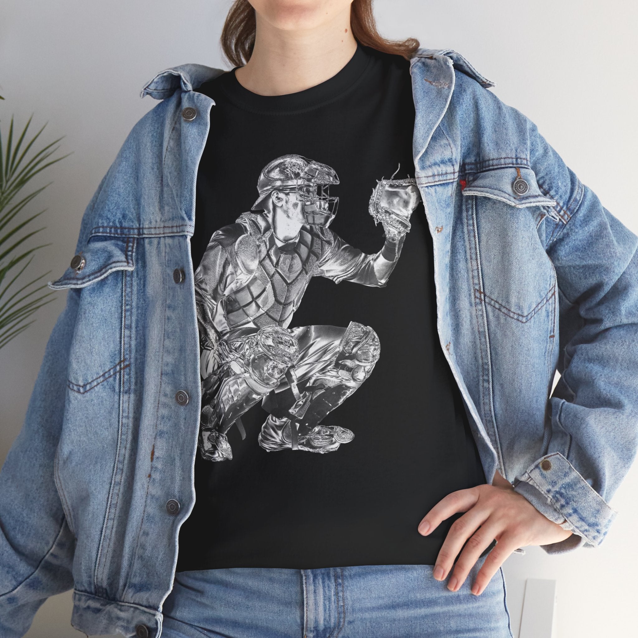 Person wearing a black t-shirt with a graphic design of a baseball catcher, paired with a denim jacket.