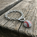 Bracelet with a baseball charm on a wooden surface