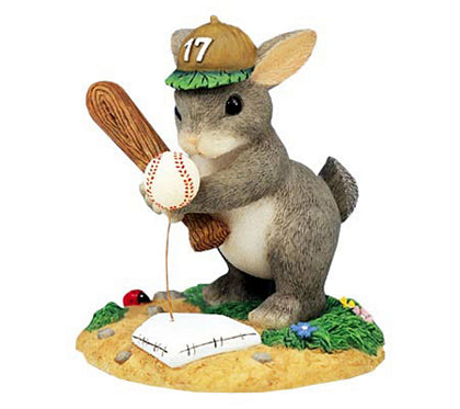 Squirrel figurine with baseball gear on a white background