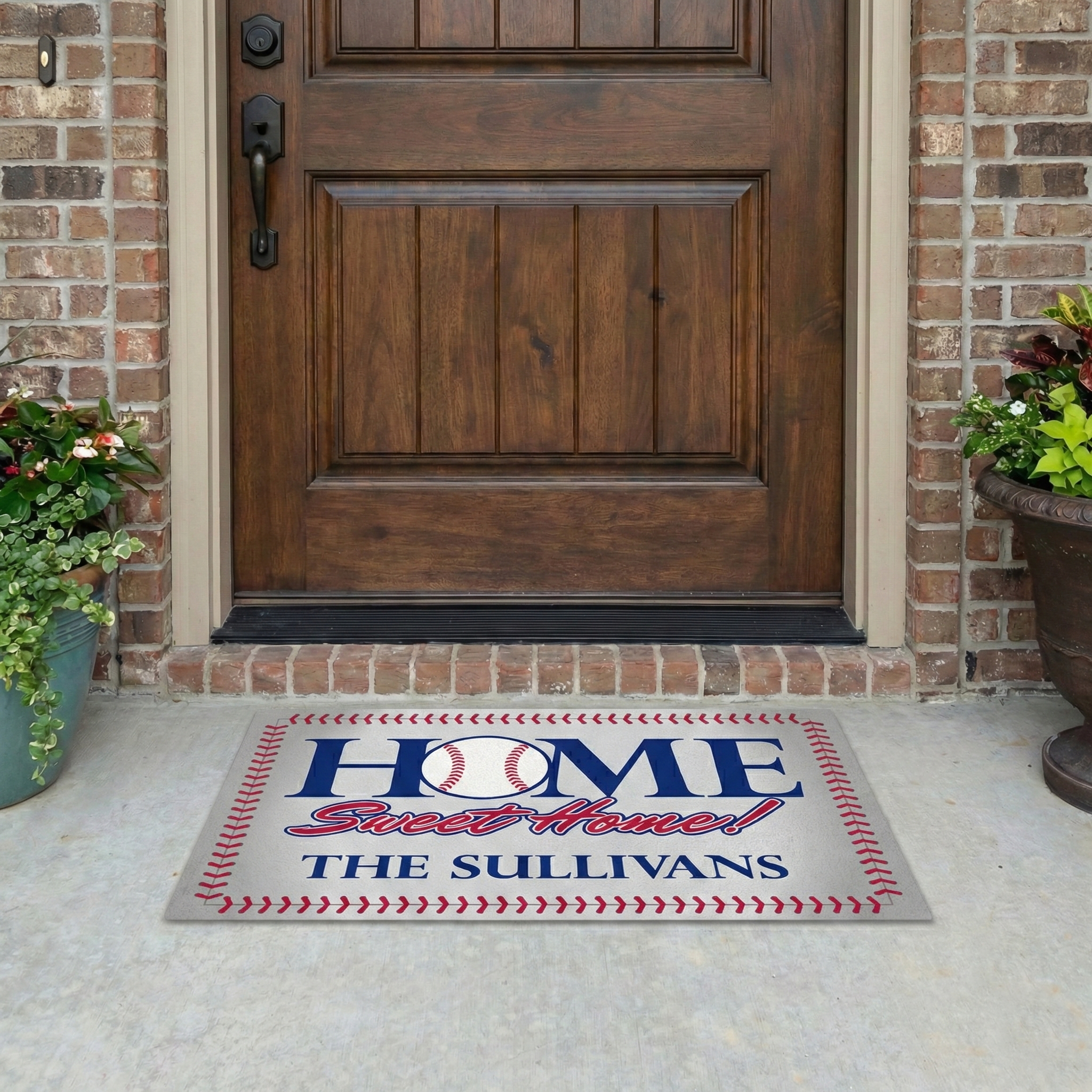 Baseball doormat with 'Home Sweet Home THE SULLIVANS' text in front of a wooden door.