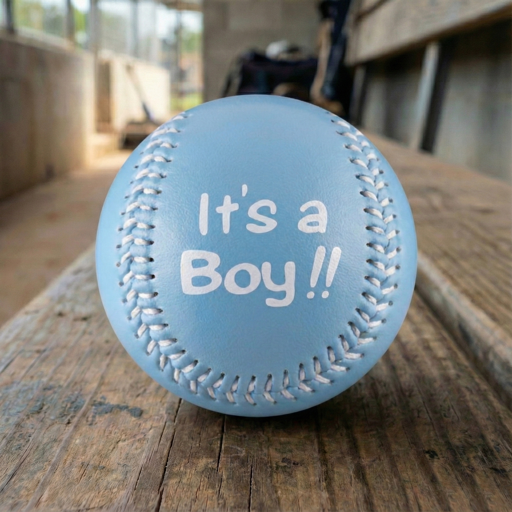 Blue baby baseball with 'It's a Boy!!' text on a wooden dugout bench