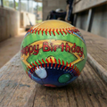 Colorful baseball with 'Happy Birthday' text on a wood baseball dugout bench
