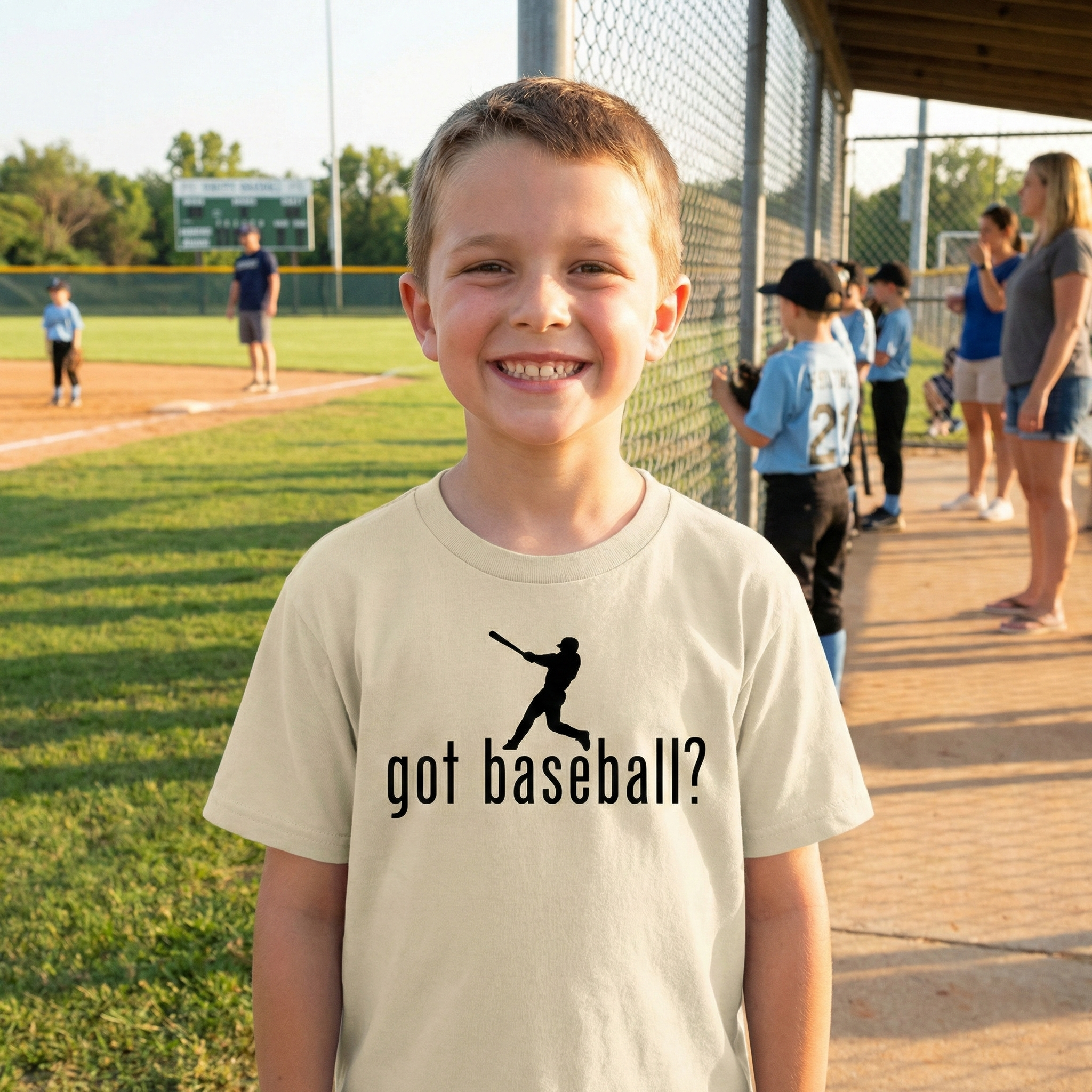 Young boy wearing a 'got baseball?' t-shirt on a baseball field.