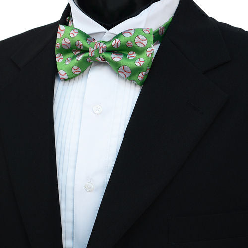 Green bow tie with baseball pattern worn by a person in a black suit and white shirt.