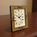 Wooden baseball alarm clock with white face and black Roman numerals on a wooden surface