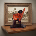 Baseball figurine in front of a framed black and white photo of a baseball player