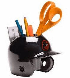 Black Orioles baseball helmet-shaped desk organizer with stationery items on a white background