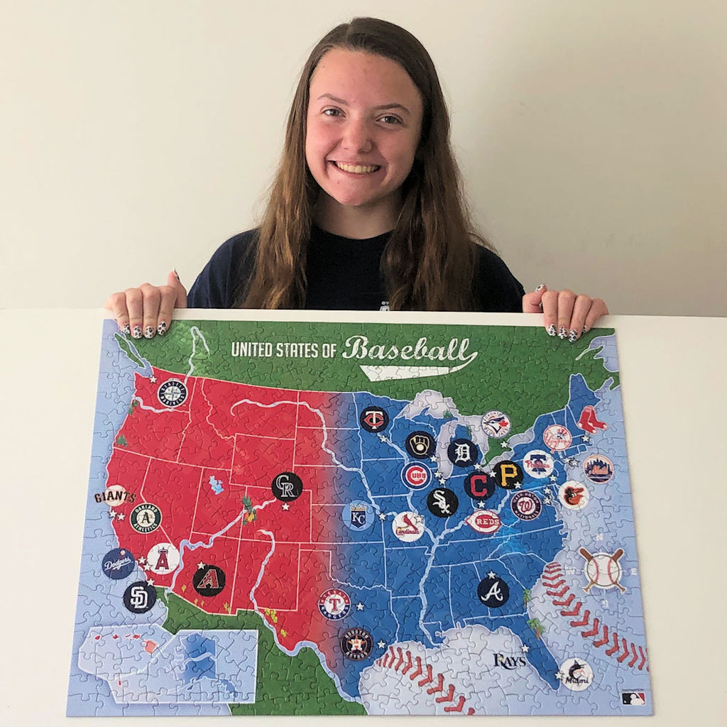 Person holding a map of the United States with Major League Baseball team logos.