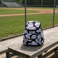 Baseballs on Black Mini Backpack on the bleachers at the ballpark. 