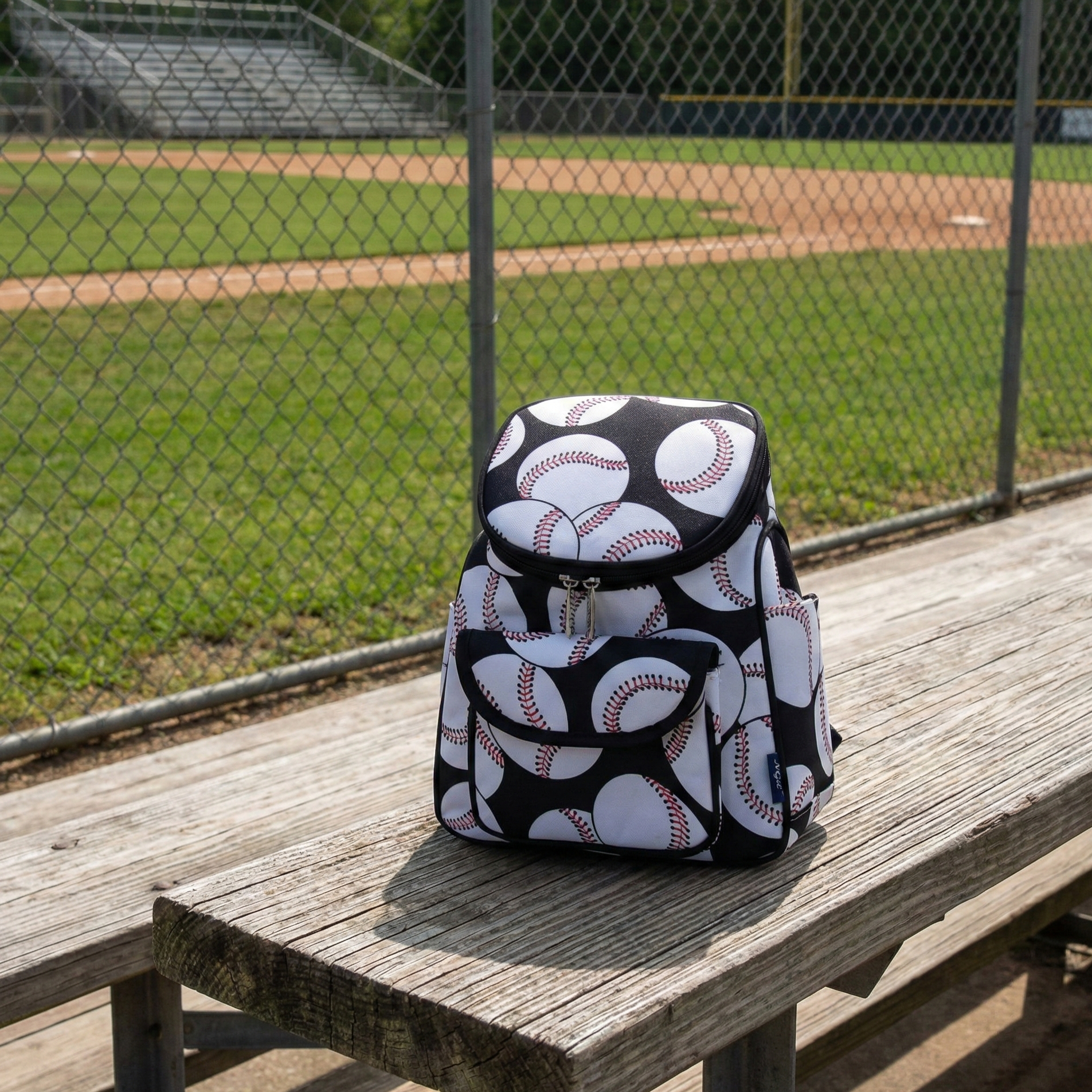 Baseballs on Black Mini Backpack on the bleachers at the ballpark. 