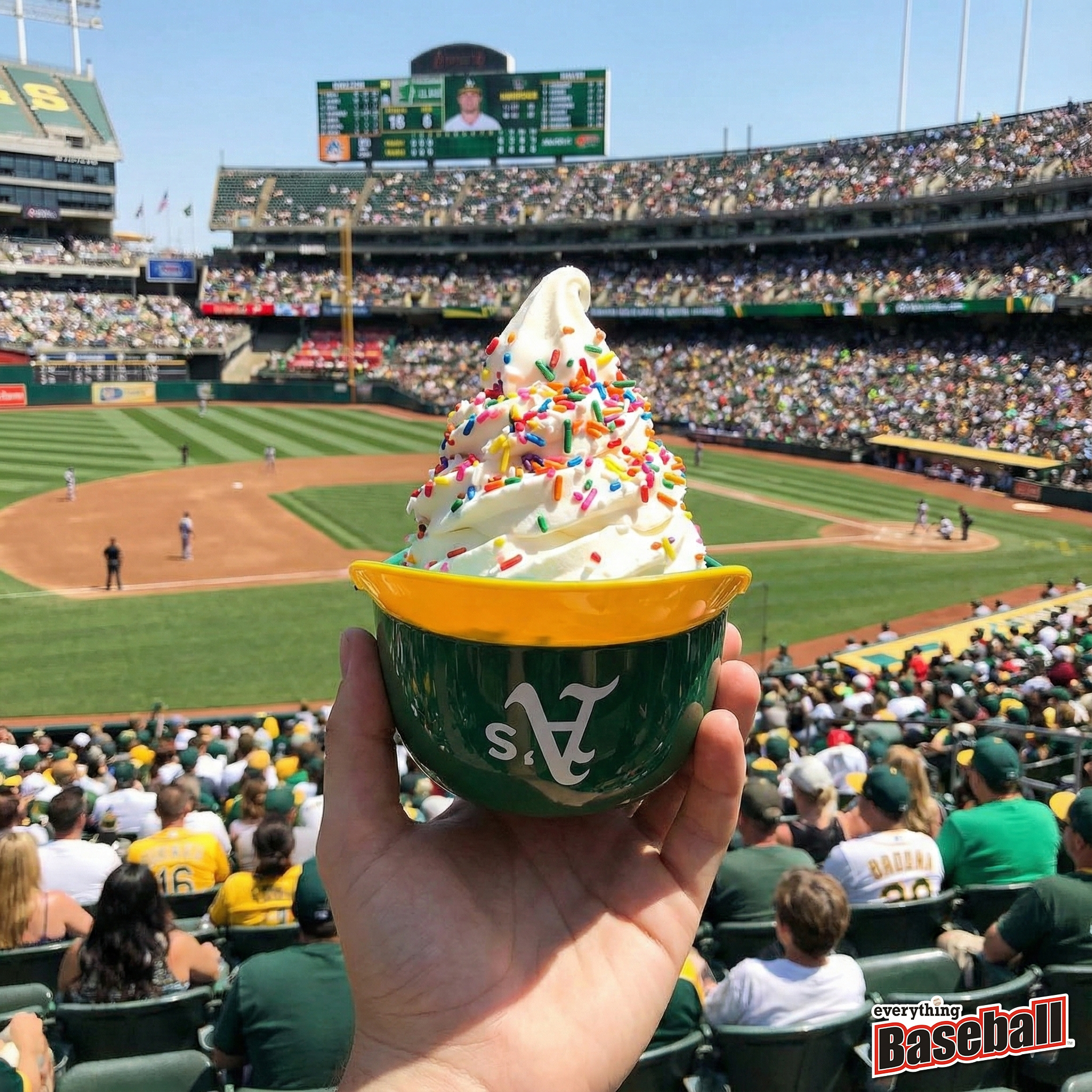 Hand holding a bowl of ice cream with colorful sprinkles at an Oakland Athletics baseball game.