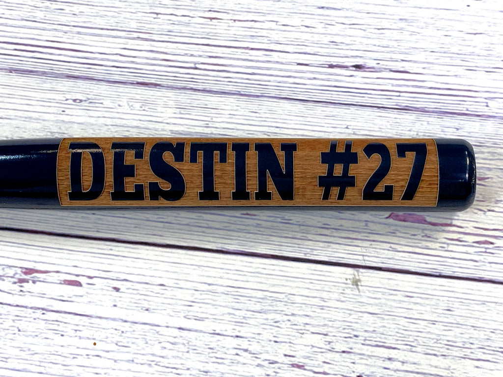 Wooden baseball bat with 'DESTIN #27' engraving in barrel