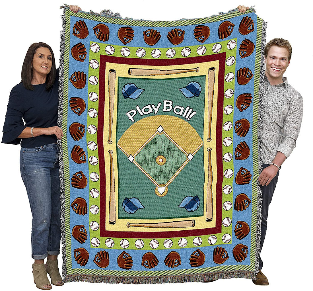 Two people holding a baseball-themed tapestry throw blanket with 'Play Ball!' text and various baseball graphics.