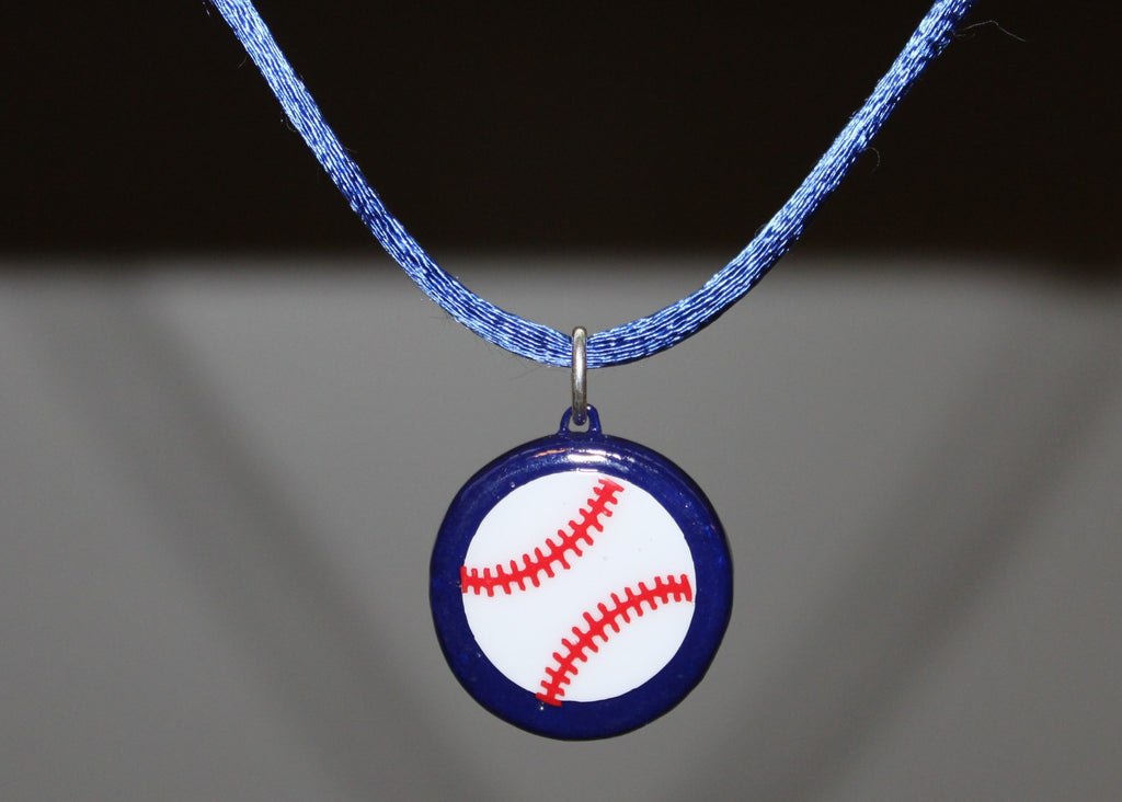 Baseball pendant necklace with blue cord on a gray background