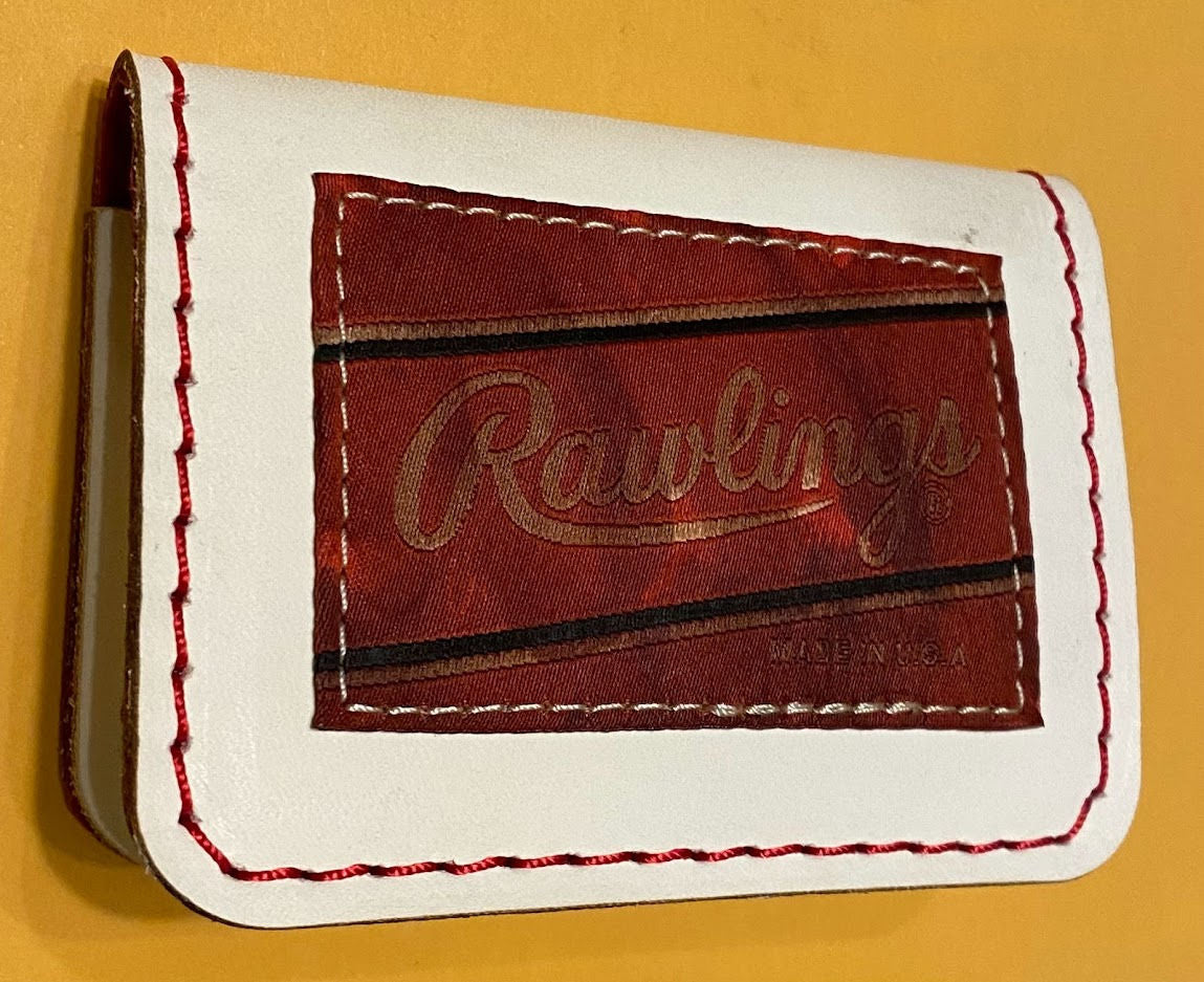 White leather wallet with 'Rawlings' branding on a yellow background