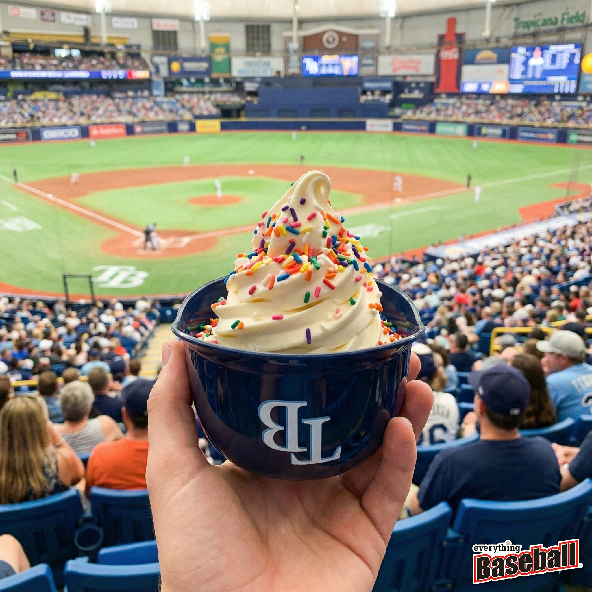 Hand holding a blue Tampa Bay Rays helmet cup with ice cream at a baseball game
