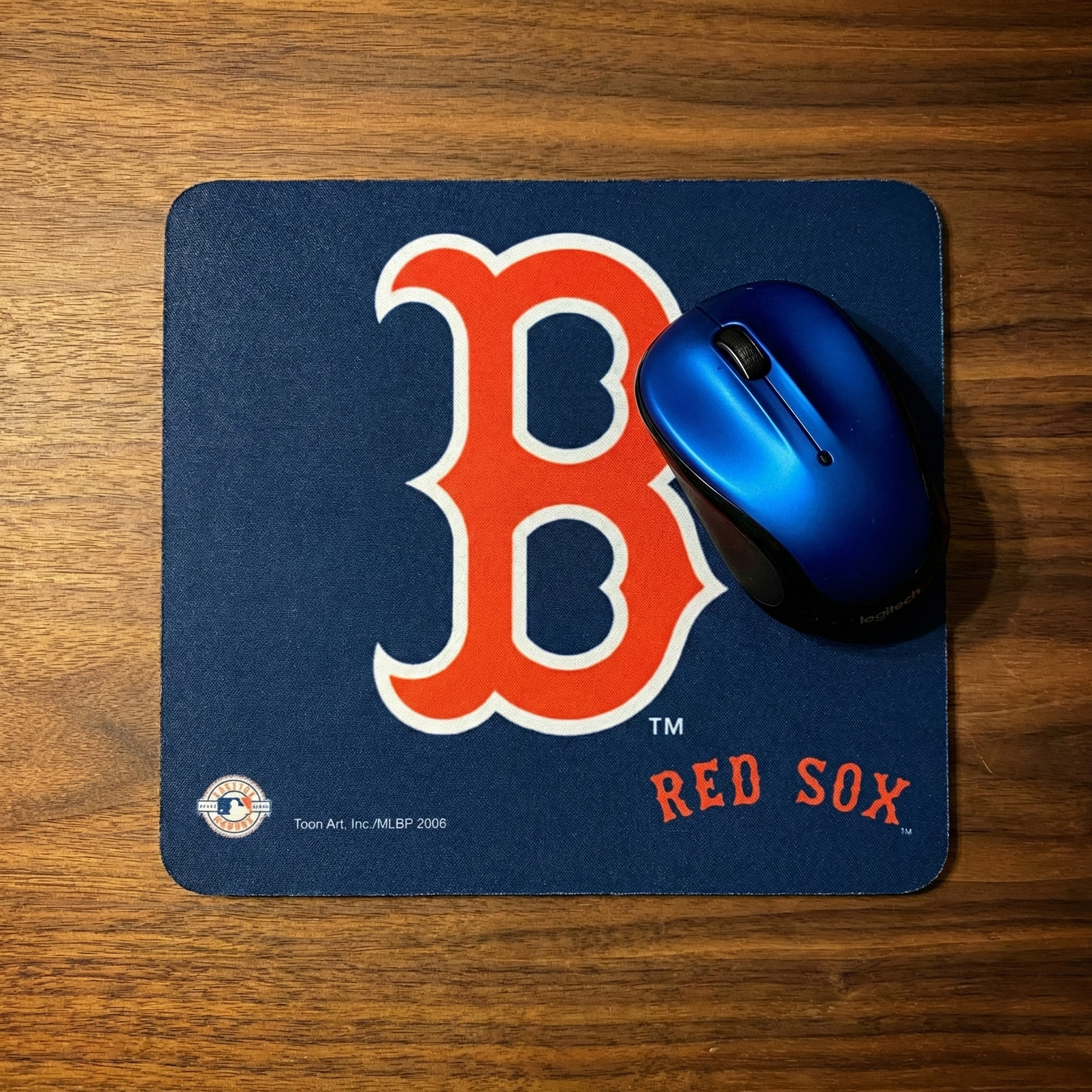 Blue mouse pad with red 'B' logo and 'Red Sox' text on a wooden surface