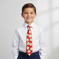 Young boy wearing a white shirt and red tie with baseball pattern on a light gray background