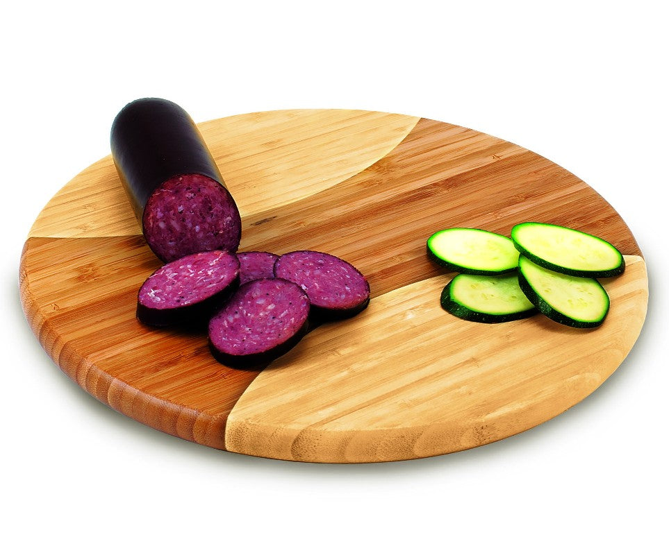 Wooden baseball cutting board with sliced salami and zucchini on a white background