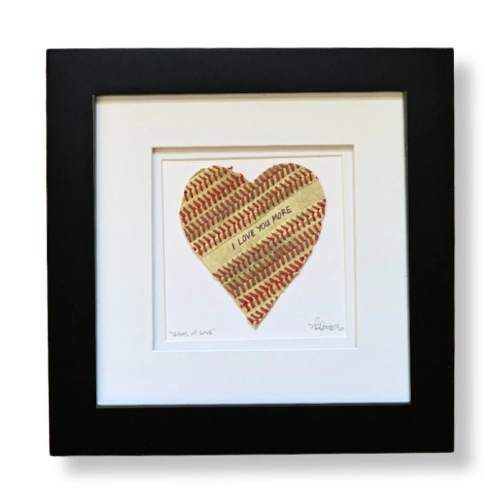 Framed heart-shaped baseball seams artwork with textured surface and text inside, on a white background.