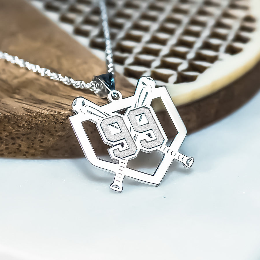 Custom silver baseball number necklace with a pendant on a wooden surface