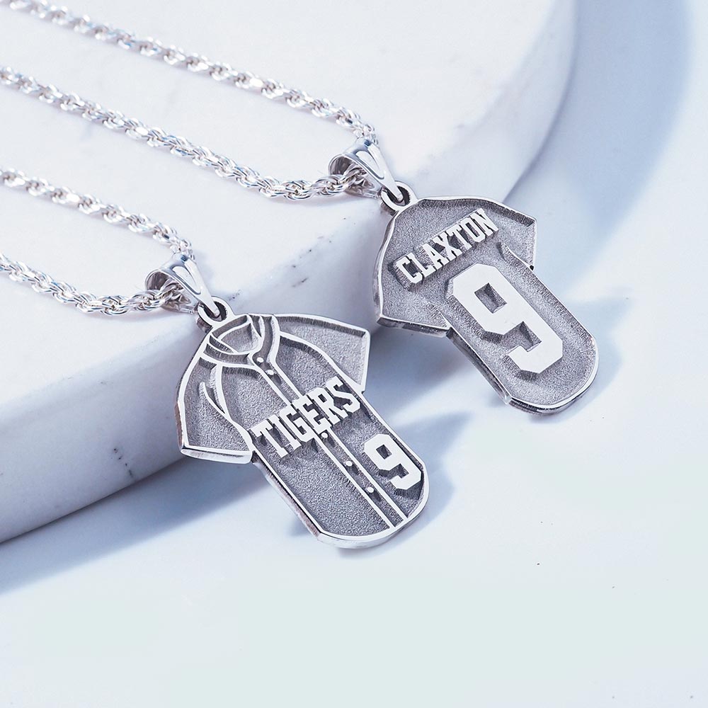Front and back of silver baseball jersey pendant on rope chain necklace on a light background