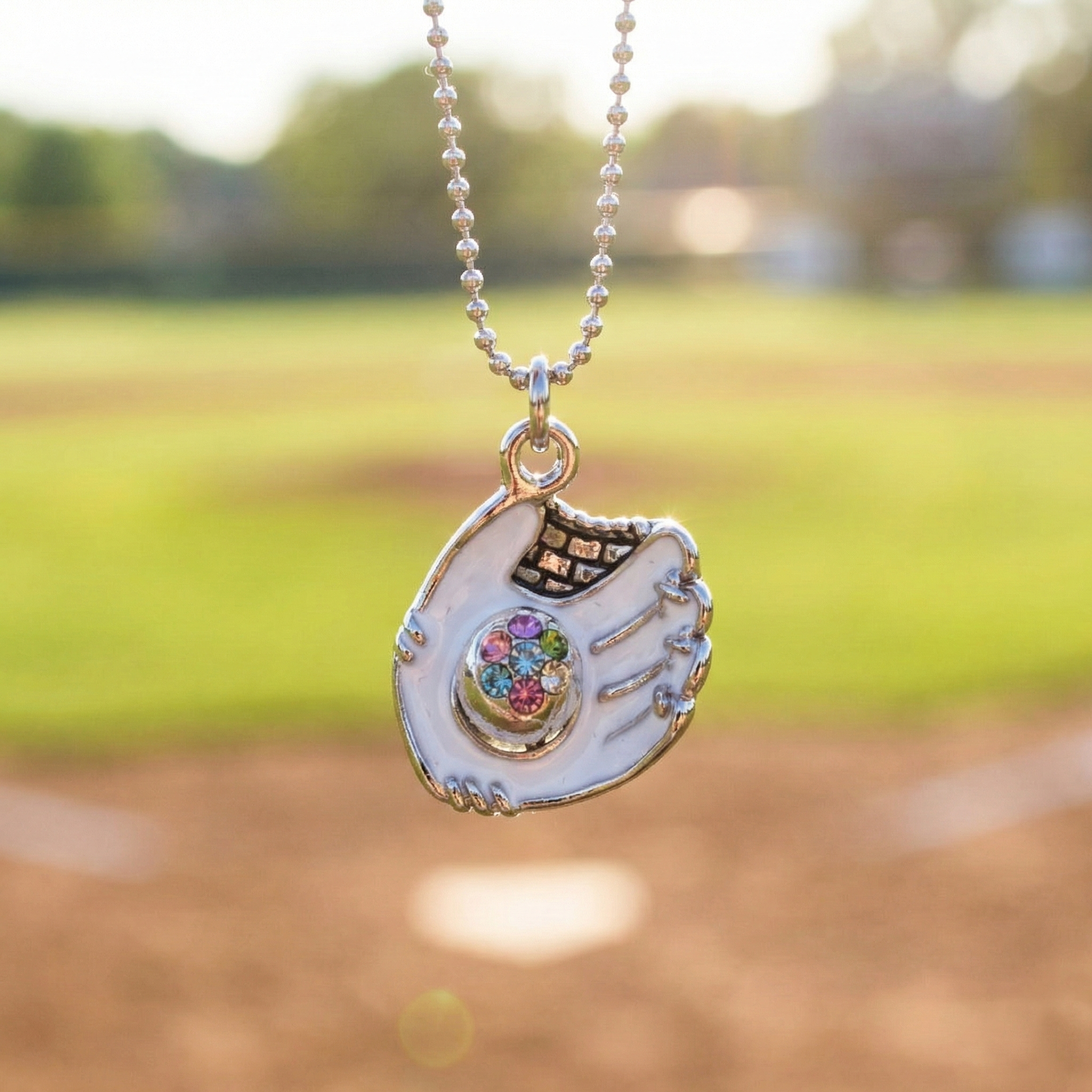 White crystal baseball glove necklace with baseball field background