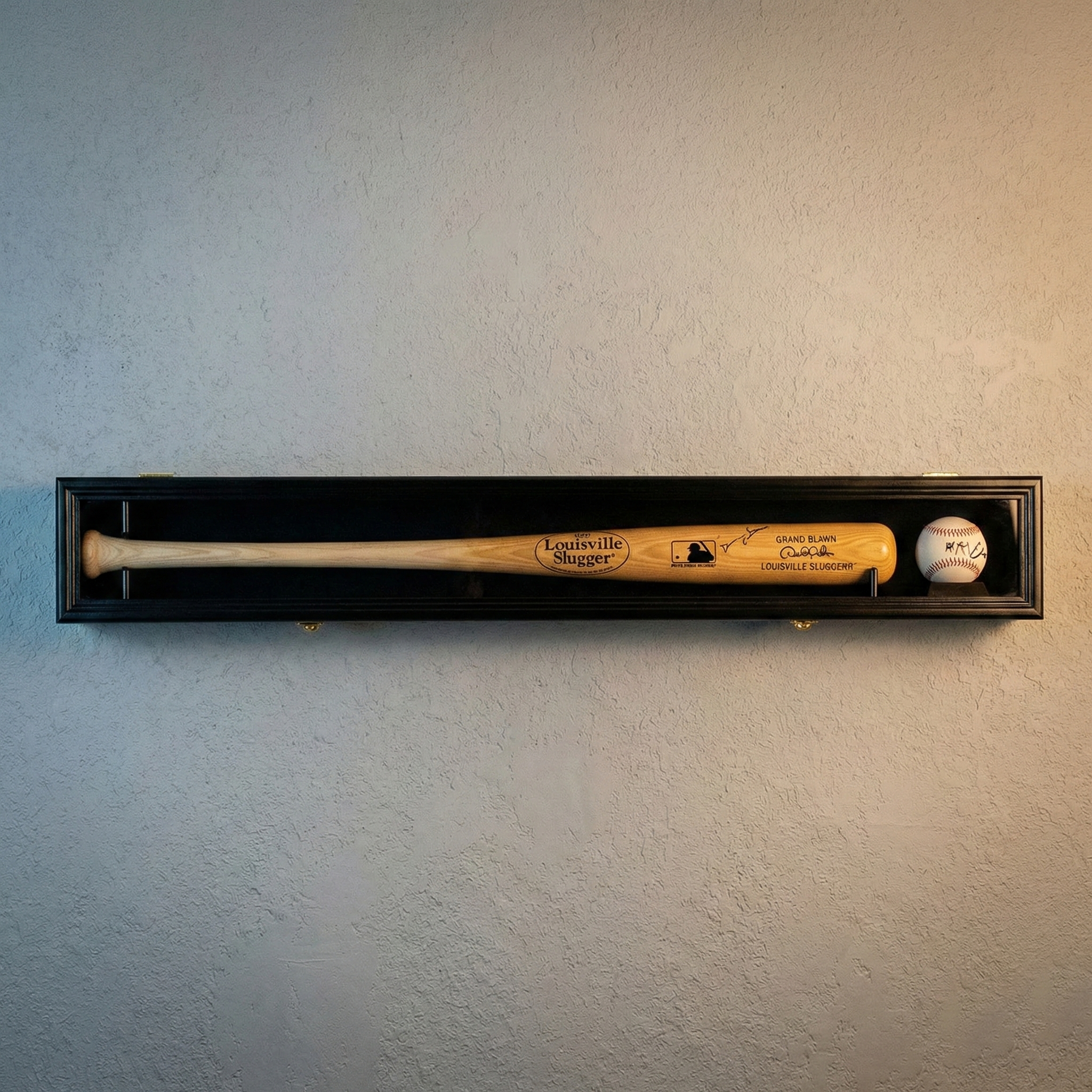 Wooden baseball bat and ball in a black display case against a light gray wall.