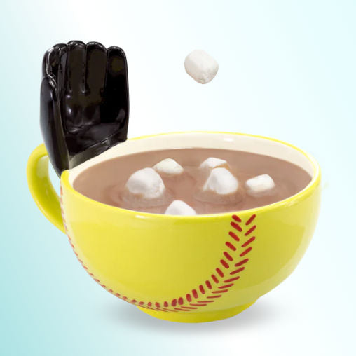 Yellow baseball-themed ceramic mug with a glove with hot chocolate and marshmallows, black glove on a light blue background
